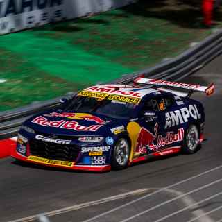 Chevrolet supercar races around a corner 
